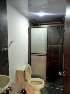 a bathroom with a toilet and a shower and a sink at la terraza in Armenia