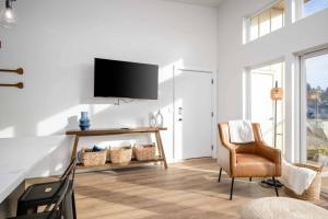 a living room with a tv and a chair at Ebb920 Modern Loft, Heart of Taft District in Lincoln City