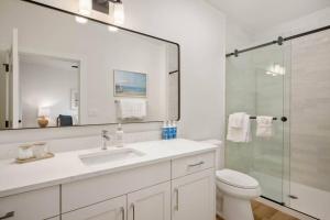 a bathroom with a toilet and a sink and a shower at Ebb920 Modern Loft, Heart of Taft District in Lincoln City +23 photos