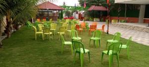 un groupe de chaises et de tables dans l'herbe dans l'établissement Royal gardens party Hall, à Wālājāpet