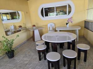 a restaurant with two tables and stools and two windows at Casa de Veraneio em Soure, Marajó PA in Soure +12 photos