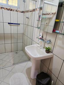a white bathroom with a sink and a shower at Casa de Veraneio em Soure, Marajó PA in Soure