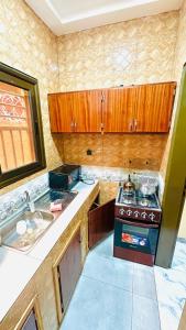 a small kitchen with a stove and a sink at PHS services 3 in Ouagadougou +19 photos