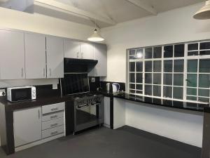a kitchen with white cabinets and a black counter top at Fiet Star in Midrand