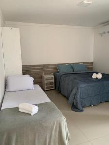 a bedroom with two beds with towels on them at Pousada Vô Nilo in Penha