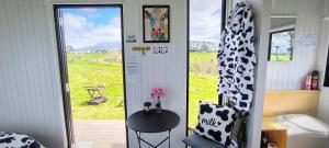 Habitación con puerta, mesa y ventana en Taranaki Creekside KIWI by Tiny Away, en Stratford