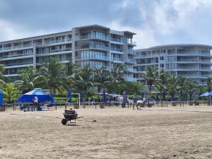 a building on the beach with people on the beach at Cartagena playa uso exclusivo Serena del mar in Cartagena de Indias