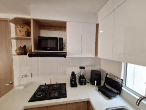 a kitchen with a stove and a microwave at Cartagena Luxury Beach Serena del Mar in Cartagena de Indias