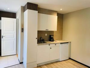 Una cocina con gabinetes blancos y un fregadero. en 4 star holiday home in SÖLVESBORG, en Hällevik 18 fotos más