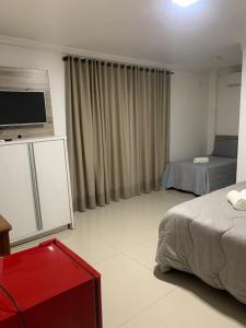 a hotel room with two beds and a flat screen tv at Pousada VÔ REY in Penha