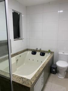 a bath tub in a bathroom with a toilet at Pousada VÔ REY in Penha +20 photos