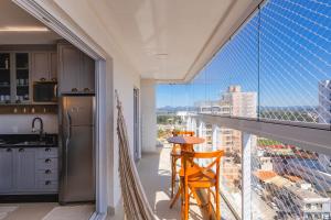 a kitchen with a balcony with a view of a city at Latitude 26° | Baleneário Piçarras in Piçarras