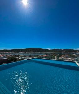 a large swimming pool with a view of a city at Flat moderno e exclusivo perto da Praia do Forte e Passagem in Cabo Frio