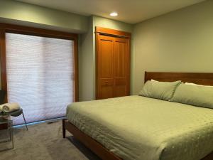 ein Schlafzimmer mit einem Bett und einem Fenster in der Unterkunft B2 Townhome with BBQ on the Deck in Hood River