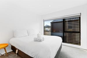 a bedroom with a large white bed and a window at Mount Views, Close To Wanaka Attractions -Love It! in Wanaka