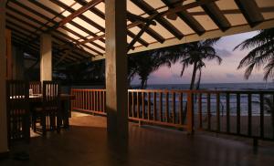 a porch with a view of the beach and the ocean at Silver Ferns Flat in Hikkaduwa