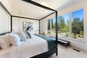 Un dormitorio con una cama grande y grandes ventanales. en Reserve Camp 25 30 Day Minimum condo, en Bend 30 fotos más