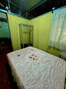 a room with a bed with red roses on it at Starfruit House in Chachagua