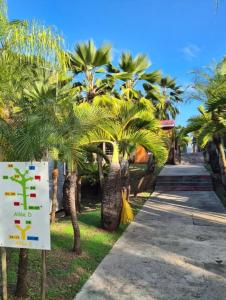 a sign in front of a bunch of palm trees at Cottage 15, Village de la Pointe in Le Vauclin