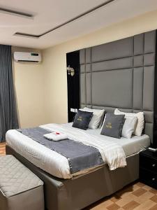 a bedroom with a large bed with two pillows at Gold Rhino Hotel and Suites Ltd in Enugu