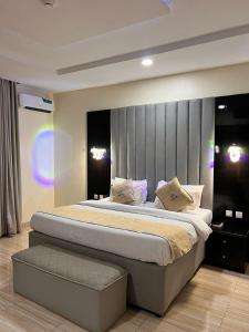 a bedroom with a large bed in a room at Gold Rhino Hotel and Suites Ltd in Enugu +4 photos