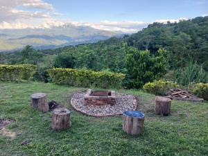 eine Feuerstelle inmitten eines Feldes mit Baumstumpfen in der Unterkunft Eco Ortalis Villeta in Estación El Salto