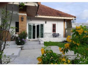 a small white house with flowers in front of it at 3BR Villa near Boat Avenue Laguna beach in Bang Tao Beach