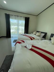 deux lits dans une chambre avec une fenêtre dans l'établissement 3P Phuket Airport Hotel, à Phuket
