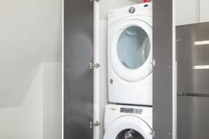una lavatrice e asciugatrice in bagno con porta di Downtown Sleek 2BR Loft a Milwaukee