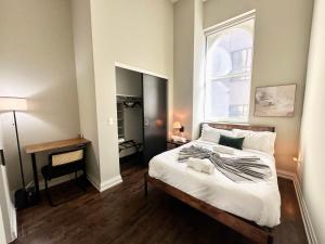 una camera da letto con un letto grande e una finestra di Downtown Sleek 2BR Loft a Milwaukee Altre 9 foto
