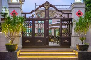 an entrance to a house with palm trees in front at Weisi Zhenpin Holiday Courtyard in Wushi +3 photos