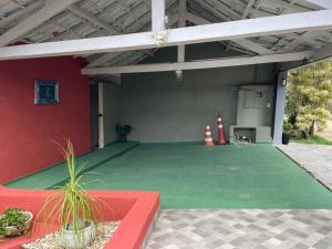 Un garaje con suelo verde y pared roja. en Pousada Vista Dell Mar, en Ubatuba