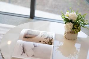 a table with a picture and a vase of flowers at Stylish Woden Apt Near Hospital w Pool, Parking in Phillip +23 photos