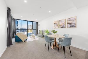 a living room with a table and chairs at Stylish Woden Apt Near Hospital w Pool, Parking in Phillip