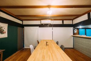 a conference room with a wooden table and chairs at hinatabocco guesthouse kominka Twin room bed in Miyaki