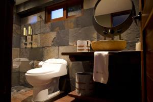 a bathroom with a toilet and a sink and a mirror at TsiaBie Hotel in Choachí