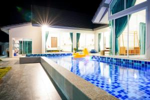 a swimming pool with blue tiles in a house at เติมเต็มพลูวิลล่า in Cha Am
