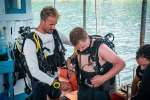 two men in life jackets standing on a boat at Taco Shack Diving Hostel Restaurant in Koh Tao