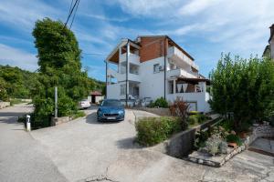 a car parked in front of a house at Apartments with parking space Palit, Rab - 22676 in Rab