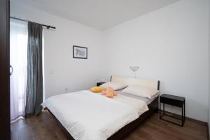 a bedroom with a bed with white sheets and a window at Apartments with parking space Palit, Rab - 22676 in Rab
