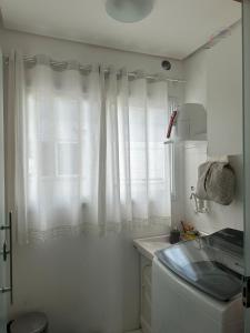 a white kitchen with a window and a sink at Apartamento em Caxias do Sul in Caxias do Sul