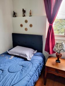 ein Schlafzimmer mit einem blauen Bett und einem Tisch in der Unterkunft Habitación con dos camas, baño privado, terraza y cocina compartida en Miraflores in Lima + 26 Fotos