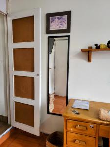 ein Spiegel an einer Wand neben einem Holztisch in der Unterkunft Habitación con dos camas, baño privado, terraza y cocina compartida en Miraflores in Lima