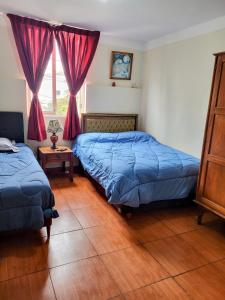 ein Schlafzimmer mit zwei Betten und einem Fenster in der Unterkunft Habitación con dos camas, baño privado, terraza y cocina compartida en Miraflores in Lima