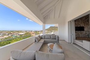 a living room with couches and a tv on a balcony at Penthouse Blue View - Aquamarine 10 in Sint Michiel