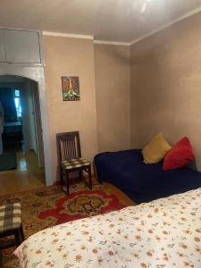 a bedroom with a bed and a chair and a table at Хостел в центре Улан-Батора in Ulaanbaatar