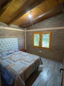 a bedroom with a bed and two windows at cabaña Mirador in Bialet Massé