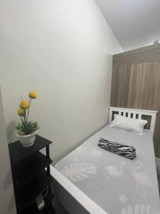 マニラにあるChill in Peace Staycation 2BR condo at Field Residences, Sucat near NAIAの小さなベッドルーム(植物のあるベッド付)