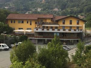 a large yellow building with cars parked in a parking lot at Hotel Castello in Montjovet
