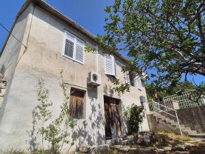 an old white building with windows and a staircase at Apartmani Aurelia in Veliki Drvenik